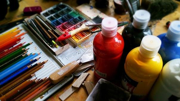 Paint supplies and colored pencils on top of table